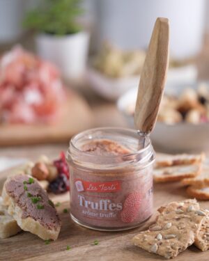 Tarti truffes en bocal ouvert avec couteau, accompagné de tartines sur planche en bois