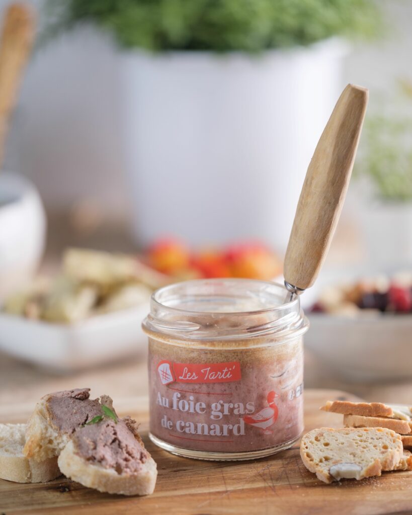 Tarti foie gras de canard Maison Lembert sur toast avec bocal ouvert et couteau sur planche en bois
