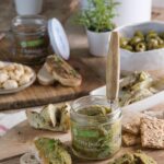Bocal de tarti petits pois cajou menthe ouvert, présenté sur une planche en bois avec une tartine dressée à côté.