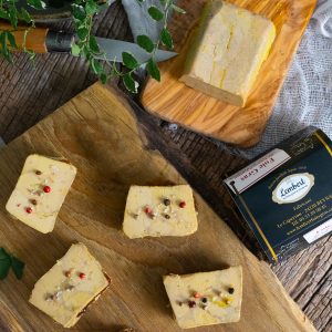 Tranches de foie gras de canard sur planche en bois, avec baies rouges et sel aromatisé