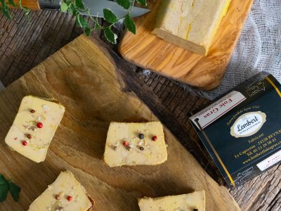 Tranches de foie gras de canard sur planche en bois, avec baies rouges et sel aromatisé