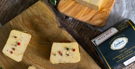 Tranches de foie gras de canard sur planche en bois, avec baies rouges et sel aromatisé
