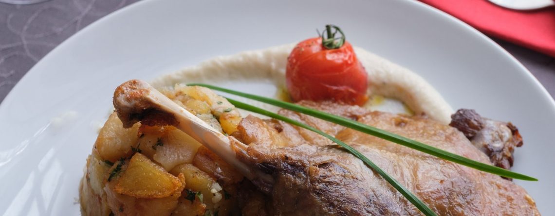 Confit de canard accompagné de pommes de terre cuisinées à la graisse de canard, légumes et tomates cerises