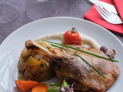 Confit de canard accompagné de pommes de terre cuisinées à la graisse de canard, légumes et tomates cerises