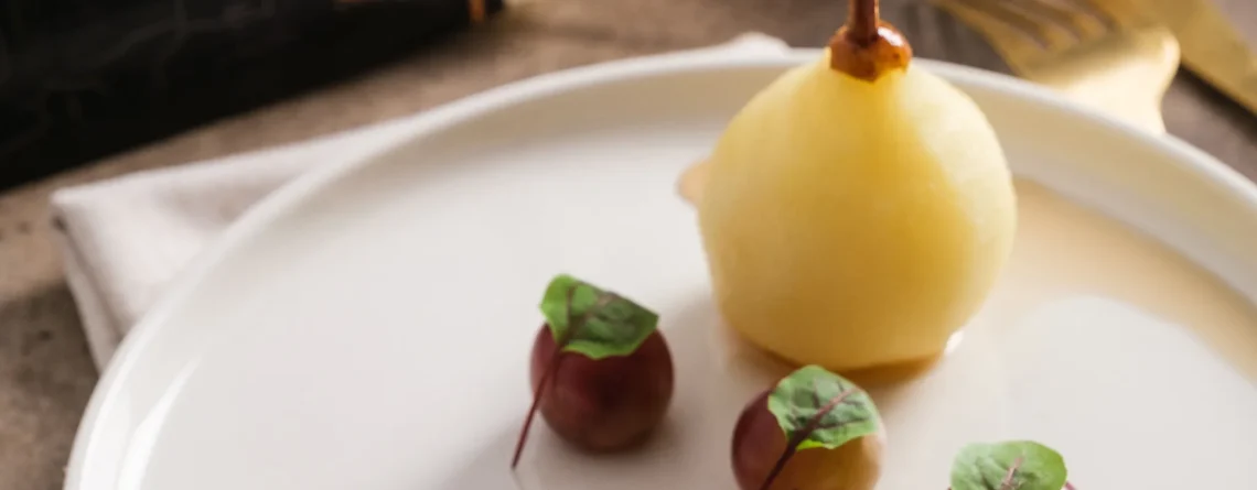 Comment servir le foie gras : assiette de foie gras de canard mi-cuit avec poire pochée, raisins et noisettes