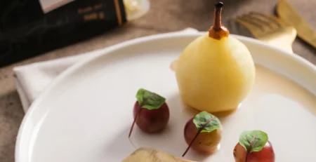 Comment servir le foie gras : assiette de foie gras de canard mi-cuit avec poire pochée, raisins et noisettes