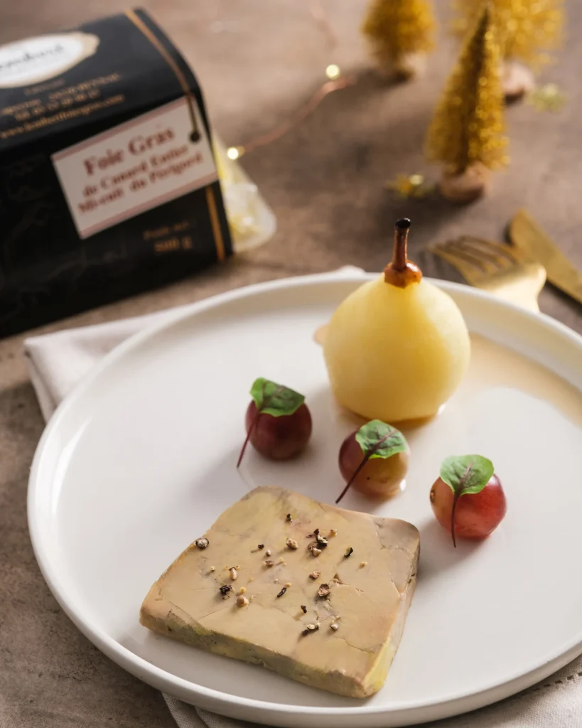 Comment servir le foie gras : assiette de foie gras de canard mi-cuit avec poire pochée, raisins et noisettes