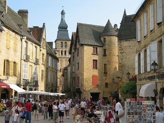 Place de la Mairie à Sarlat-la-Canéda animée un jour d’été, idéale pour savoir où manger en Dordogne