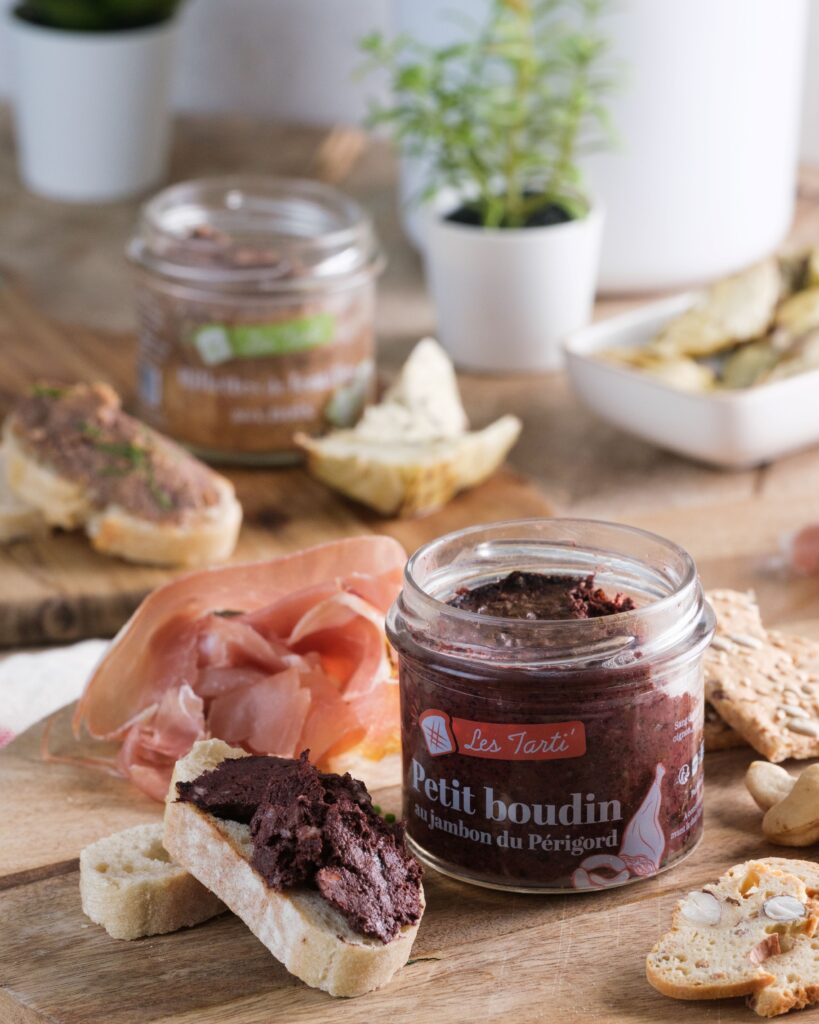 Tarti petit boudin au jambon du Périgord sur toast avec bocal ouvert sur planche en bois
