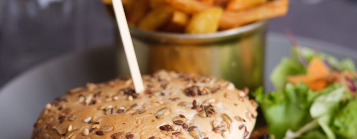 Burger au canard confit à Beynac, effiloché de canard, servi avec des frites maison et une petite salade colorée