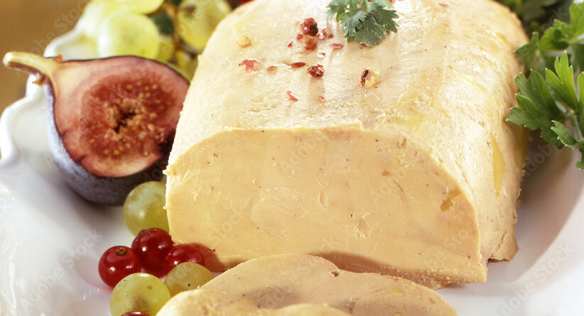 Comment cuire un foie gras : foie gras de canard présenté sur une assiette blanche avec figues fraîches et fruits pour une dégustation gourmande