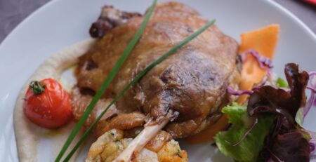 Accompagnementsconfit de canard : des pommes de terre dorées, préparé avec des produits locaux et de qualité, accompagné d'une présentation soignée.