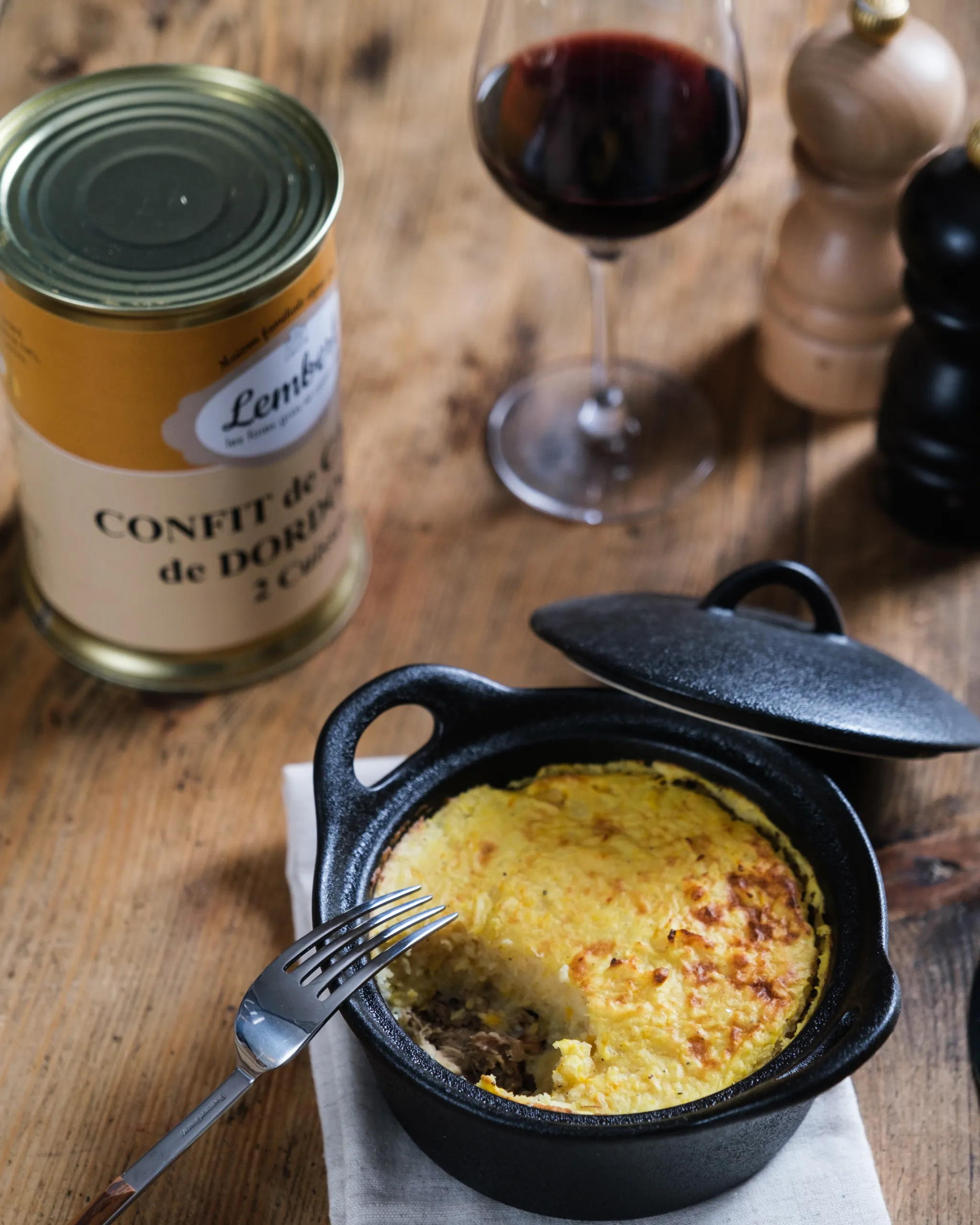 Parmentier de canard confit aux pommes de terre servi en cocotte individuelle avec notre confit de canard 2 cuisses